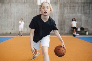 Portrait of female basketball player practicing at sports court - MASF26110