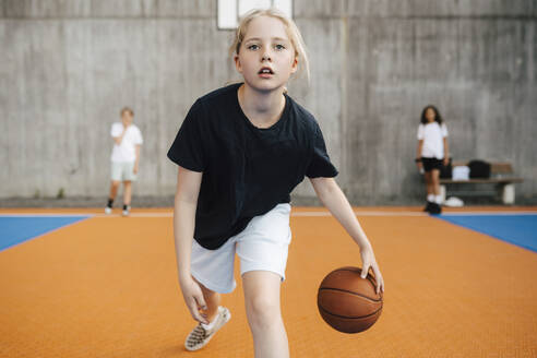 Porträt einer Basketballspielerin beim Üben auf dem Sportplatz - MASF26110