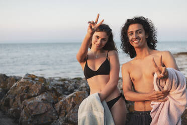 Porträt eines jungen Paares mit Friedenszeichen am Meer - MASF26198