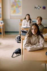 Lächelndes Teenager-Mädchen mit Freunden im Klassenzimmer - MASF26294