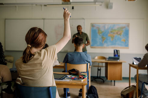 Jugendlicher Schüler hebt die Hand beim Lernen im Klassenzimmer der High School - MASF26331