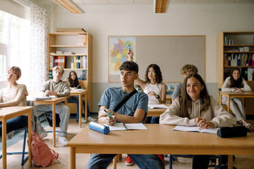 Mädchen und Jungen beim Lernen am Schreibtisch im Klassenzimmer - MASF26341