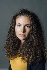 Young woman with brown curly hair in studio - MEUF04266