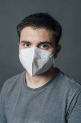 Young man wearing white protective face mask during COVID-19 - MEUF04276