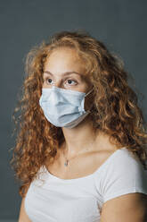 Young blond woman in protective face mask during COVID-19 - MEUF04295