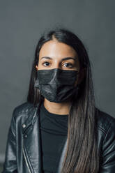 Young woman wearing protective face mask during COVID-19 - MEUF04340