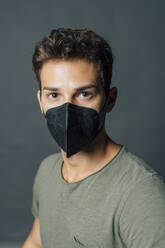 Young man wearing black protective face mask during COVID-19 - MEUF04368