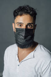 Young man wearing protective face mask in studio - MEUF04384