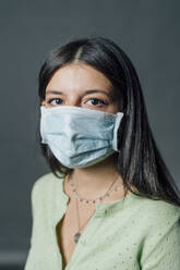 Young woman in protective face mask during COVID-19 - MEUF04394