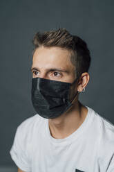 Young man in protective face mask during pandemic - MEUF04406