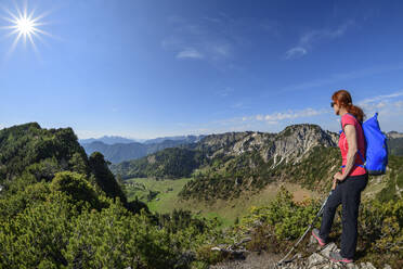 Young woman hiking at Hochfelln mountain range during sunny day - ANSF00002