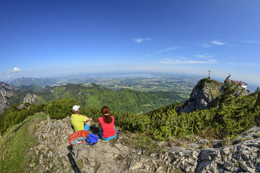 Couple looking at view while sitting on Hochfelln mountain during vacation - ANSF00003