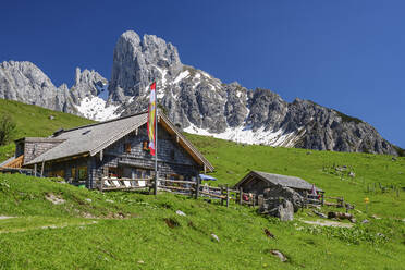 Blick auf eine gebaute Berghütte in einer grünen Landschaft im Winter - ANSF00032