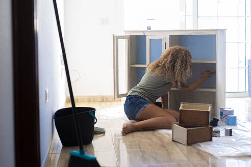 Ältere Frau malt Schrank zu Hause - SIPF02595