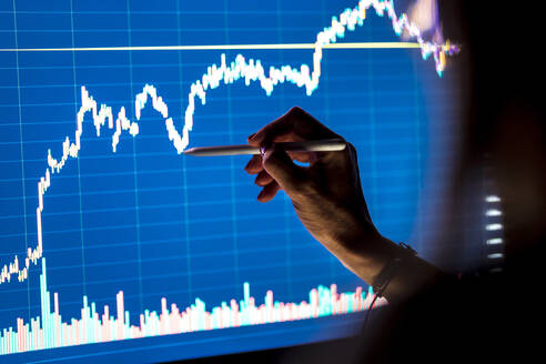 Female business professional checking stock market graph on screen - DLTSF02227
