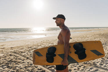 Mittlerer Erwachsener Mann mit Surfbrett am Strand - JRVF01978