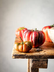 Nahaufnahme von mehreren roten Tomaten auf einem Holztisch - ADSF31023