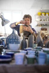 Spanien, Balearen, Frau macht Keramik in Werkstatt - ISF25281