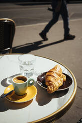 Frankreich, Paris, Croissant, Kaffee und Glas Wasser auf dem Tisch eines Straßencafés - ISF25298