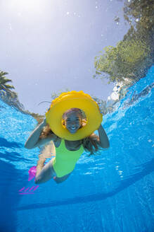 Spanien, Mallorca, Lächelnde Frau schwimmt im Pool mit aufblasbarem Ring - ISF25314