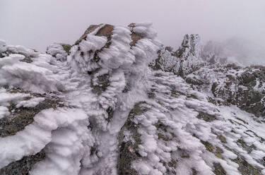 Schnee auf einer felsigen Gebirgskette im Nationalpark Sierra de Guadarrama bei diesigem Wetter - ADSF31090