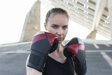Serious female athlete with boxing glove - PNAF02377