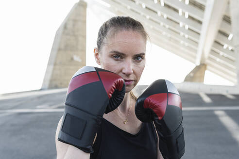 Seriöse Sportlerin mit Boxhandschuh - PNAF02377