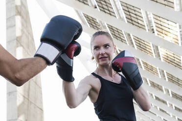Weiblicher Boxer beim Training mit einem Fitnesstrainer - PNAF02404