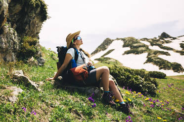 Wanderin mit Rucksack, die sich auf einem Berg ausruht - OMIF00130