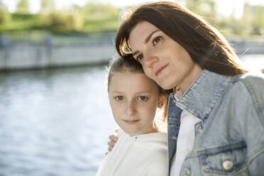 Mother leaning on daughter at embankment - LLUF00146