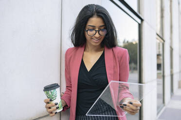 Female professional using futuristic digital tablet - JCCMF04161