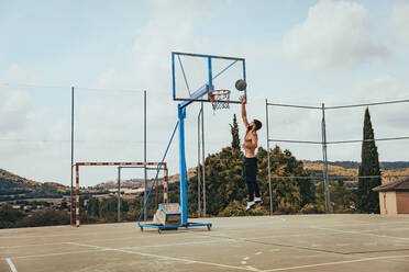 Young man practicing basketball at sports court - ACPF01339