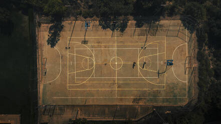 Männliche Freunde spielen zusammen Basketball auf einem Sportplatz - ACPF01343