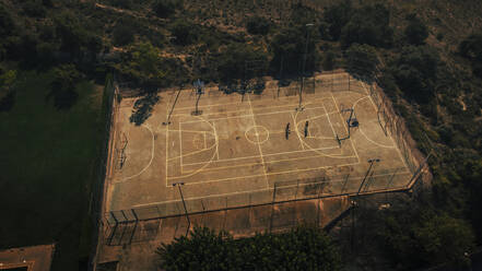 Junge Männer spielen Basketball bei Sonnenuntergang - ACPF01344