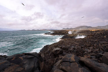 Blick auf das schäumende Meer, den Strand Ciclos und den Vulkan Guincho im Golfo Yaiza auf Lanzarote, Kanarische Inseln, Spanien - ADSF31133