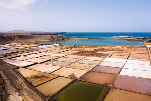 Von oben Salinas de Janubio gegen Berge und Meer mit Horizont unter bewölktem Himmel in Yaiza Lanzarote Kanarische Inseln Spanien - ADSF31134