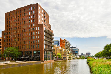 Rippled Fluss zwischen Park und zeitgenössischen Wohnhaus Außenbereiche unter bewölktem Himmel in Amsterdam Holland - ADSF31189