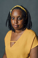 Woman with braided hair against gray background - MEUF04458