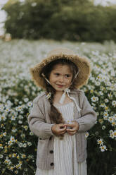 Mädchen mit Hut steht auf einem Blumenfeld - SSGF00009