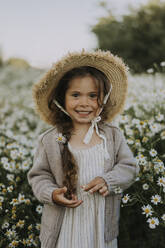 Smiling girl with hat standing at flower field - SSGF00011