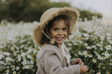 Lächelndes Mädchen mit Blume im Hut auf einem landwirtschaftlichen Feld - SSGF00015