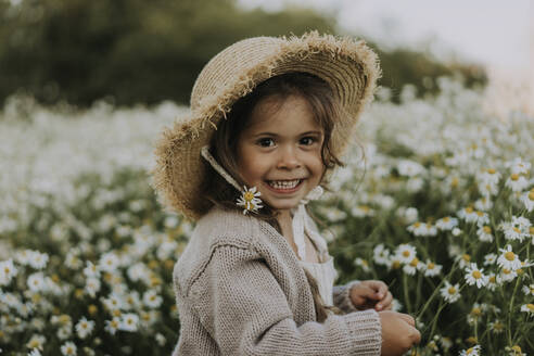 Smiling girl with flower in hat at agricultural field - SSGF00015