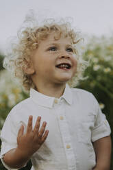 Glücklicher kleiner Junge auf einem Blumenfeld - SSGF00026