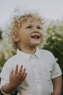 Glücklicher kleiner Junge auf einem Blumenfeld - SSGF00026