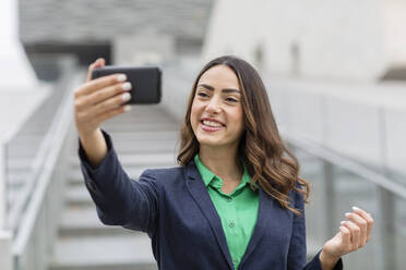 Lächelnde Geschäftsfrau nimmt Selfie durch Smartphone - EIF02173