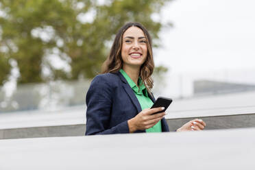 Lächelnde Geschäftsfrau mit Smartphone in der Hand - EIF02182
