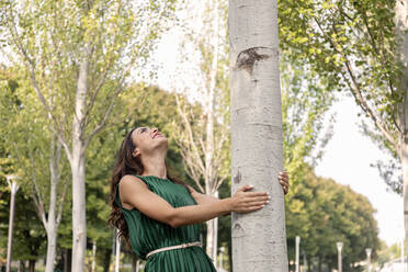 Junge Frau steht unter einem Baum im Park - EIF02202