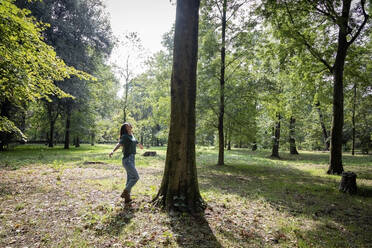 Frau mit ausgestreckten Armen unter einem Baum stehend - EIF02234