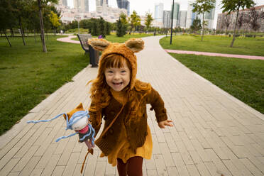 Fröhliches Mädchen mit Puppe läuft im Park - SSGF00050