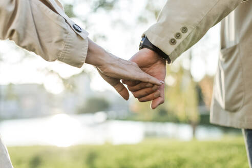 Mature man holding hand of senior woman - LLUF00222